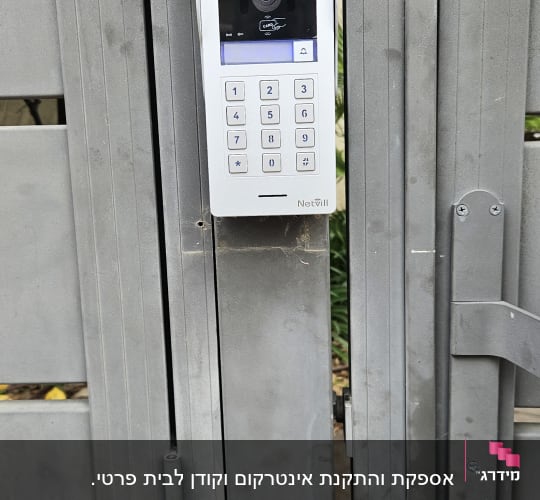 אינטרקום עם מצלמה ומקשים על שער מתכת אפור